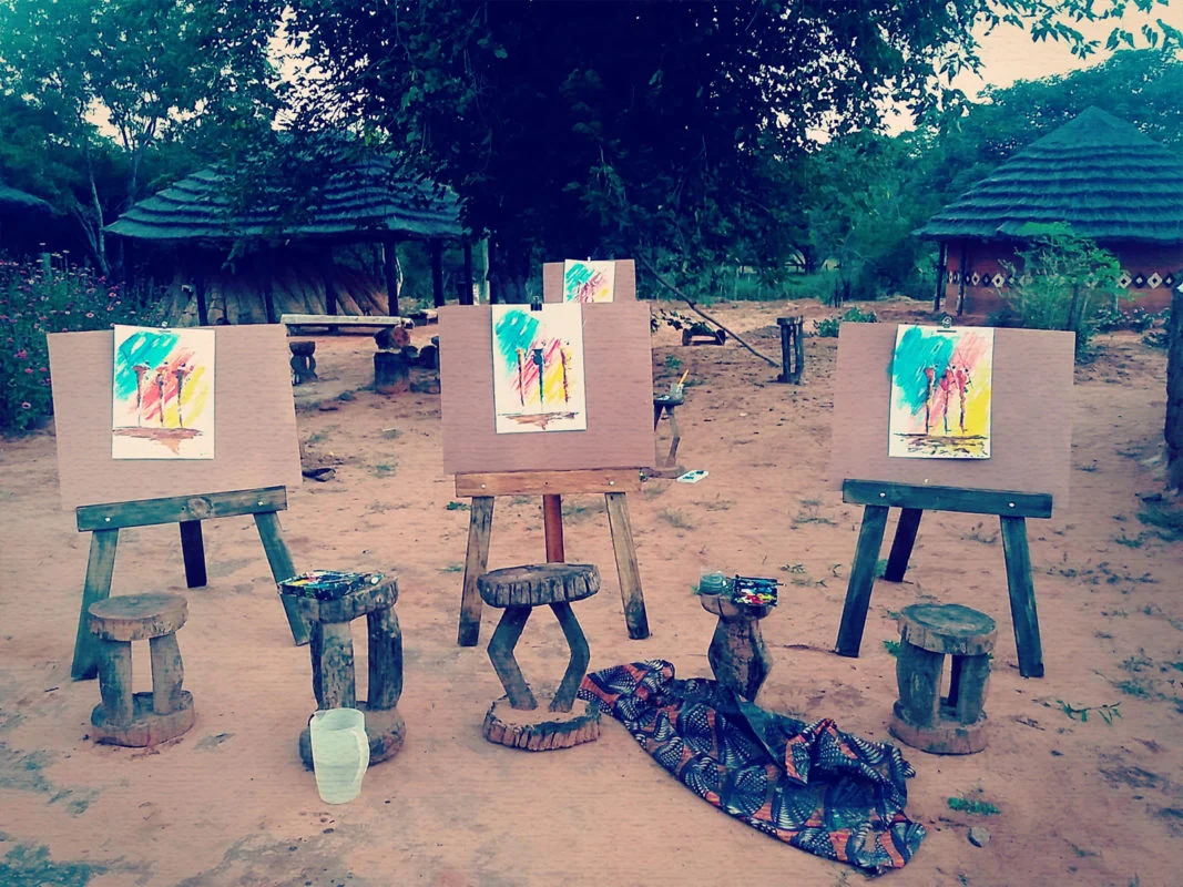 Paintings on easels in an outdoor village art workshop