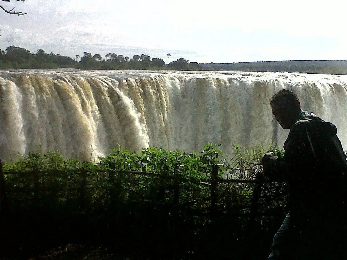 Visitor looking across Victoria Falls from a rainforest viewpoint