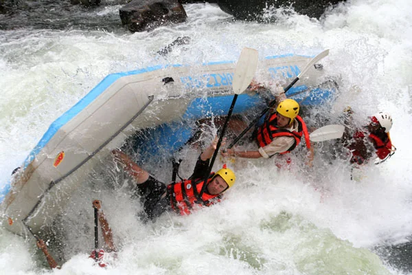 Whitewater rafters and an upturned raft in a breaking rapid