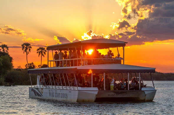 Two-deck cruise boat on the Zambezi River at sunset