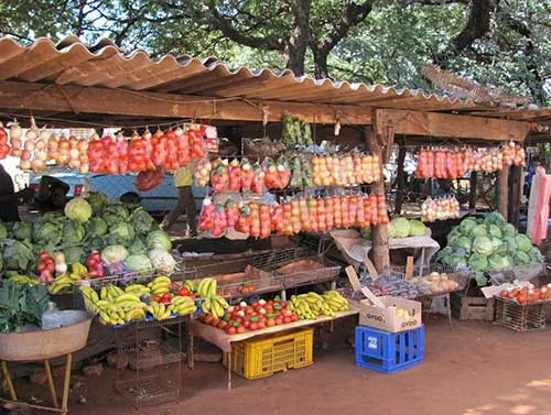 Produce stalls displaying vegetables and fruit at a township market