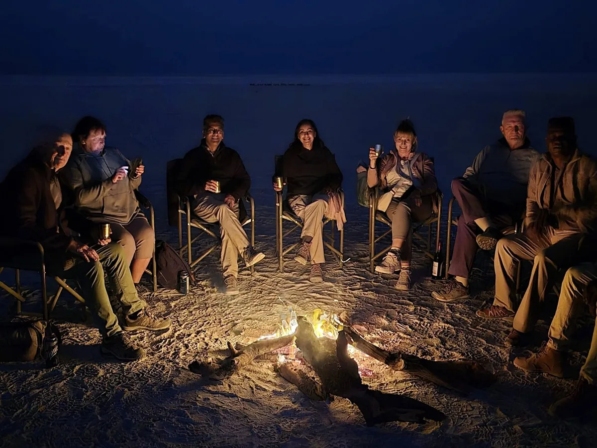 Safari guests gathered around a Botswana campfire